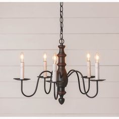 a chandelier with five lit candles hanging from it