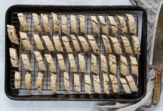 sliced up chicken on a baking sheet with a knife and fork next to the tray