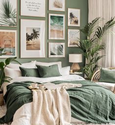 a bedroom with green walls and pictures on the wall above the bed, along with plants