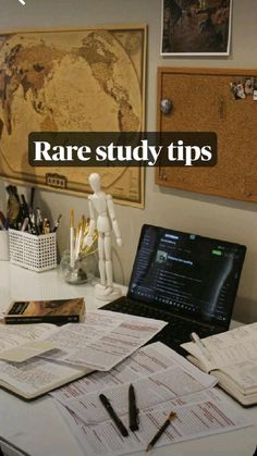 a desk with a laptop computer on top of it next to some books and papers