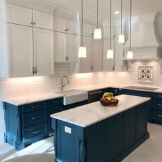 a large kitchen with blue cabinets and white counter tops