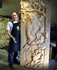 a man standing next to a carved wooden door