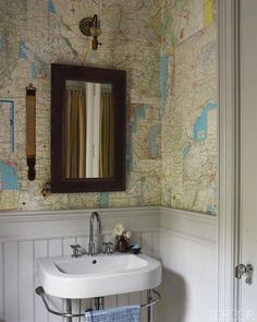 a white sink sitting under a bathroom mirror next to a wall mounted faucet