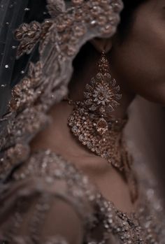 a close up of a woman wearing a veil and earrings