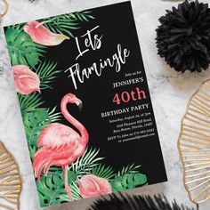 a flamingo themed birthday party with black and pink decorations, feathers and palm leaves