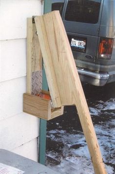 a piece of wood sticking out of the side of a building next to a van