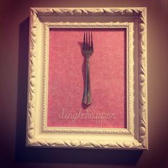 there is a framed picture with a fork on it