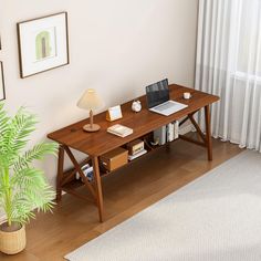 a wooden table with a laptop on it next to a potted plant and window