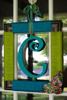 a blue and green letter hanging on the side of a window