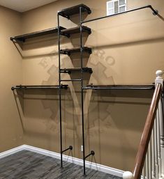 an empty room with some shelves on the wall and a stair case in the corner