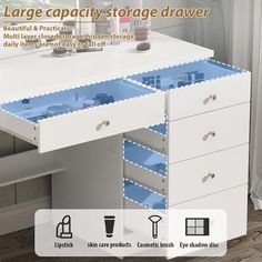 an open drawer on top of a white desk with blue drawers and shelves underneath it