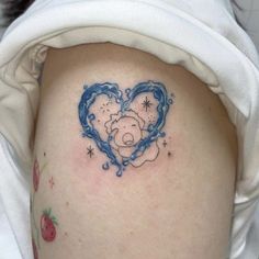 a woman with a heart shaped tattoo on her thigh