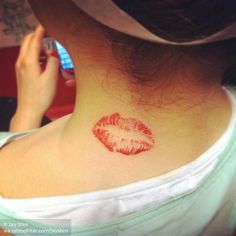 a woman with a red lip tattoo on her neck