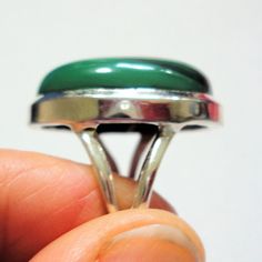 "Green malachite ring is a rare top quality natural bull's eye polished oval malachite gemstone ring in solid sterling silver ring size 7. Green malachite gem is a polished oval cabochon with Its perfect bulls eye formation in this best quality malachite gemstone. The oval malachite gemstone is approximate 18mm x 22mm in size. Solid sterling green malachite gemstone ring is size 7 and stamped \"925\" for solid sterling silver inside the band. Malachite Properties: Malachite is often called the \ Oval Green Onyx Rings, Malachite Gemstone Ring, Oval Malachite Emerald Ring, Fine Jewelry With Round Malachite, Green Oval Malachite Jewelry, Handmade Malachite Ring Jewelry, Green Malachite Rings With Polished Finish, Silver Round Malachite Jewelry, Malachite Rings