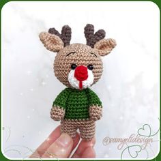 a crocheted reindeer with a red nose and green shirt