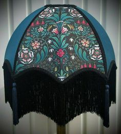 an elaborately decorated umbrella with fringes on it's sides and flowers painted on the top