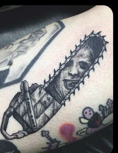 a tattoo with a chainsaw on the arm