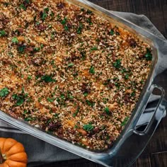 a casserole dish filled with lots of food on top of a wooden table