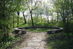 a stone bench sitting in the middle of a forest