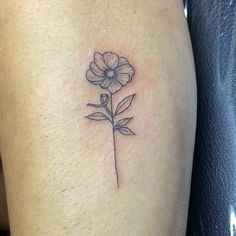 a small flower tattoo on the thigh