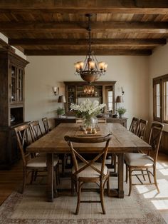 a dining room table with chairs and a chandelier hanging from it's ceiling