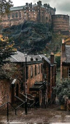 an image of a castle that is on top of a hill in the city with stairs leading up to it