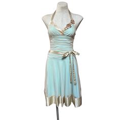 Embrace nostalgia with this Vintage 1990s XOXO (Betsey Johnson Style) Ruched Bodycon Light Blue Bandage Dress. Gold mesh tulle overlay, matching satin tie belt, and satin trim enhance the simple fit & flare silhouette, creating a romantic, balletcore look that's irresistibly coquettish. Features: * Women's Semiformal Dress * Fit and Flare Silhouette * 1990s Era * Material: 100% Polyester, Semi-stretch * Sleeveless, Halter * Solid Blue w Mesh Tulle Overlay * Made in USA * Sweetheart Neckline * Tea Length (Midi/calf length) * Ruched Bodycon * Back Zipper Closure Size: Womens XXS Measurements laying flat approximately Bust 32 in / 81 cm Waist 24 in / 61 cm Hip 42 in / 107 cm Length 41 in / 104 cm Condition: Pre-Owned Like New Garment has no stains, odors or defects and is clean and ready to w Vintage Fitted Ruched Dress, Vintage Fitted Halter Neck Dress, Blue Bandage Dress, Simple Fits, Semi Formal Dresses, Fame Dr, Dress Gold, Tea Length, Gold Dress