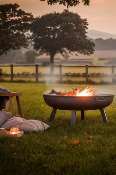 a fire pit sitting on top of a lush green field