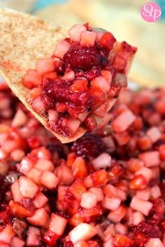 a spoon full of food that is being held over the top of some kind of bowl