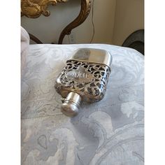 a silver lighter sitting on top of a bed next to a gold headboard and mirror