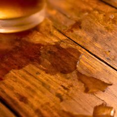 a glass of beer sitting on top of a wooden table