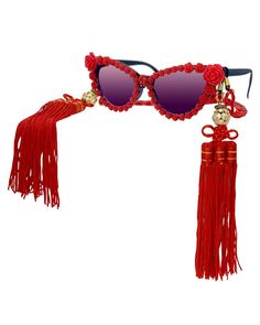 These elegant, statement-making sunglasses will instantly make you the life of the party! Beautifully intricate rose blossoms completely encircle the black cat eye frames. A marbled red acrylic neck chain dangles with ease, and can easily be converted into a fabulous mask chain! These sunnies wouldn't be complete without the removable geisha inspired silk tassels that hang effortlessly at each temple. Each tassel is embellished with shiny crystal rhinestone encrusted gold disco balls. You are su Red Plastic Party Jewelry, Elegant Plastic Jewelry For Parties, Making Sunglasses, Novelty Sunglasses, Black Cat Eye, Silk Tassels, The Black Cat, Mask Chain, Black Cat Eyes