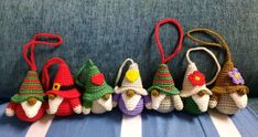 small crocheted christmas ornaments are lined up on a blue striped couch with white and green stripes