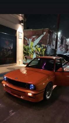 an orange car parked in front of a building