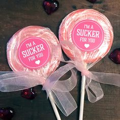 two lollipops with i'm a sucker for you stickers on them