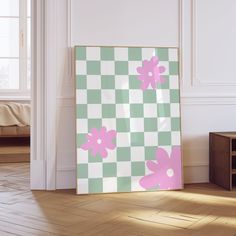 a pink and green flowered painting is on the wall next to a wooden table