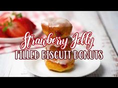 strawberry jelly filled biscuit donuts on a white plate with strawberries in the background