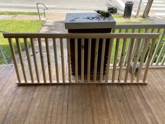 a box sitting on top of a wooden deck next to a fence and grass area