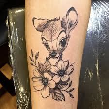 a tattoo on the leg of a woman with flowers and a deer's head