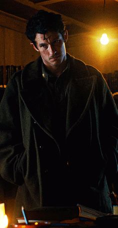 a man standing in front of a cake with candles on it