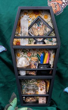 a shelf with many items on it and butterflies flying around the area in front of it