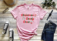 This retro Christmas Candy Crew T-Shirt is perfect for family or friends to wear while making holiday treats! Enjoy the best time of year in this cute and cozy festive shirt. This classic unisex jersey short sleeve tee fits like a well-loved favorite. Soft cotton and quality print make users fall in love with it over and over again. These t-shirts have ribbed knit collars to bolster shaping. The shoulders have taping for better fit over time. Dual side seams hold the garment's shape for longer.  *100% Airlume combed and ringspun cotton (fiber content may vary for different colors) *Light fabric (4.2 oz/yd² (142 g/m *Retail fit *Tear away label *Runs true to size Washing instructions: Non-chlorine: bleach as needed; Tumble dry: low heat; Iron, steam or dry: medium heat; Do not dryclean; Mac Festival Shirts, Group Shirts, Candy Making, Making Shirts, Candy Land, Crew Shirt, Holiday Baking, Softest Sweater, Holiday Treats