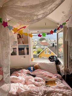 a bedroom with pink bedding and lots of hanging paper decorations on the ceiling above it