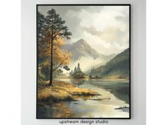 a painting hanging on the wall above a lake with trees and mountains in the background