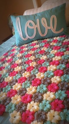 a crocheted bedspread with the word love on it