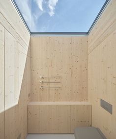 an empty room with skylight and wooden walls