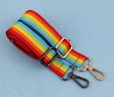 a multicolored strap with two metal hooks attached to it on a blue background