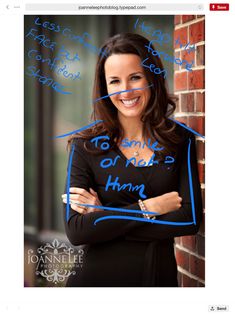 a woman standing in front of a brick wall with her arms crossed and writing on it