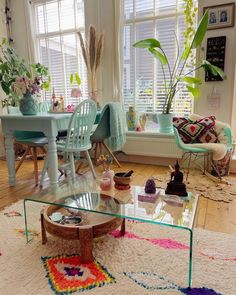 a living room filled with furniture and lots of plants on top of a glass table