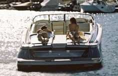 two people sitting on the back of a boat